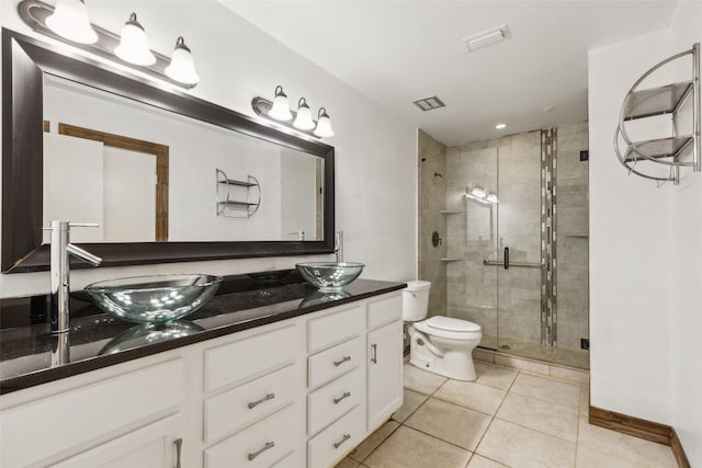 full bath with toilet, a shower stall, a sink, and tile patterned flooring