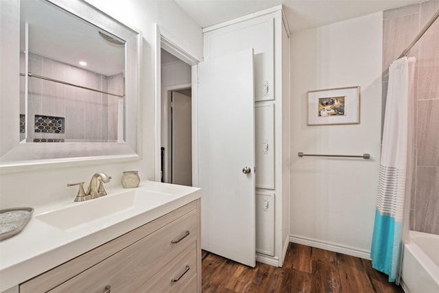bathroom with vanity, shower / bath combo, wood finished floors, and baseboards