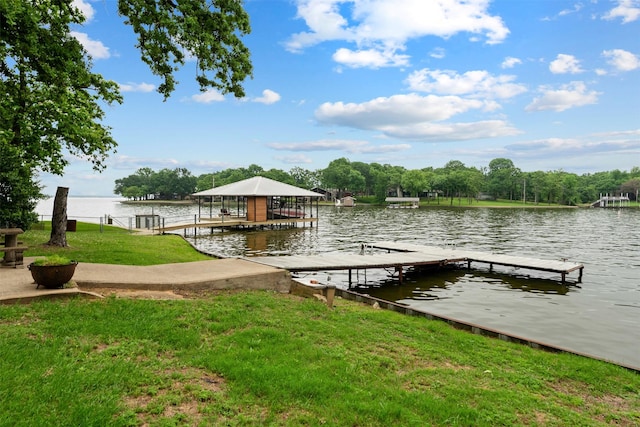 view of dock with a lawn and a water view