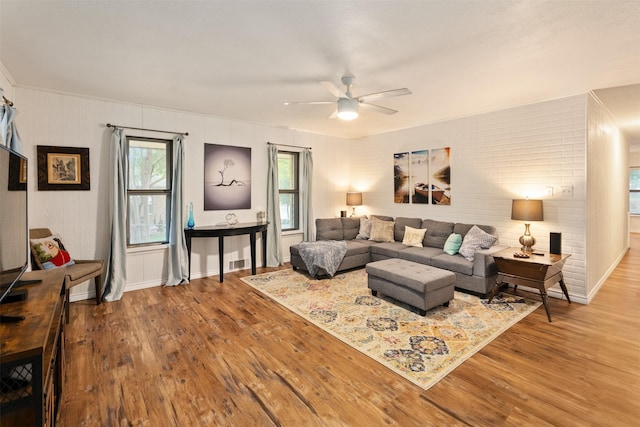 living area featuring visible vents, ceiling fan, wood finished floors, and baseboards