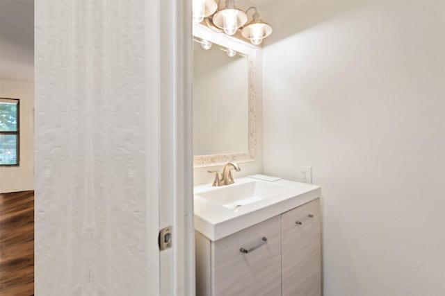 bathroom with vanity, a notable chandelier, and wood finished floors