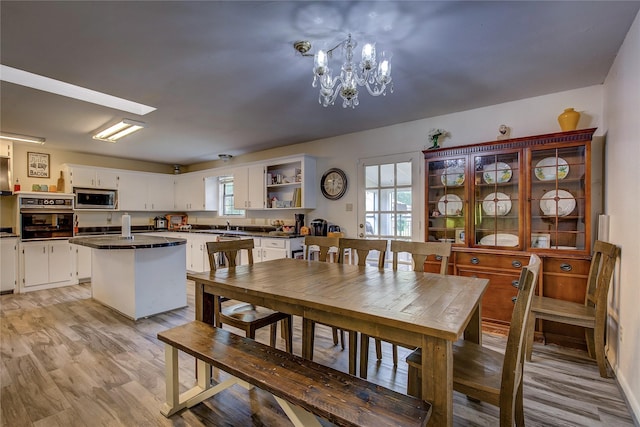 1829 County Road 1103, Sulphur Springs, TX 75482 - dining space featuring a chandelier, healthy amount of natural light, light wood-style floors, and baseboards