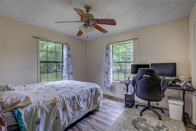 1829 County Road 1103, Sulphur Springs, TX 75482 - bedroom featuring an office area, wood finished floors, a ceiling fan, a closet, and baseboards