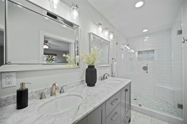 full bath with a stall shower, marble finish floor, double vanity, and a sink