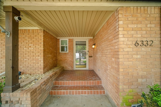 doorway to property featuring brick siding