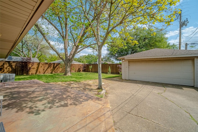view of patio / terrace featuring an outbuilding, a detached garage, and a fenced backyard