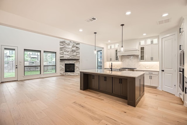 16090 Inca Dove Ct, Frisco, TX 75035 - kitchen with a tile fireplace, white cabinets, light countertops, backsplash, and oven