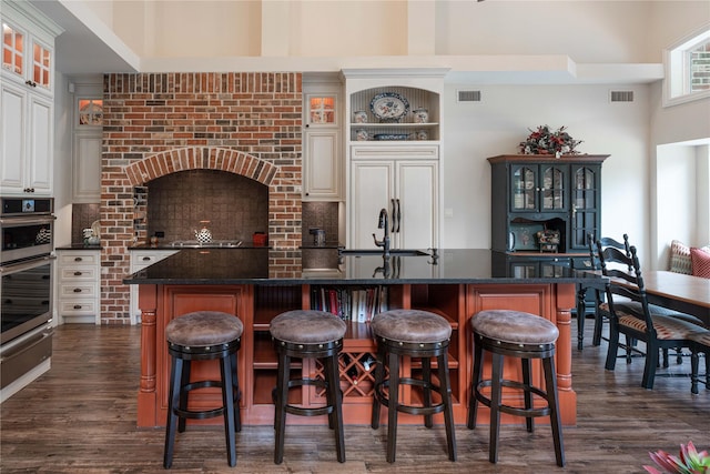 7307 Stallion Cir, Flower Mound, TX 75022 - kitchen with a sink, a warming drawer, glass insert cabinets, and visible vents