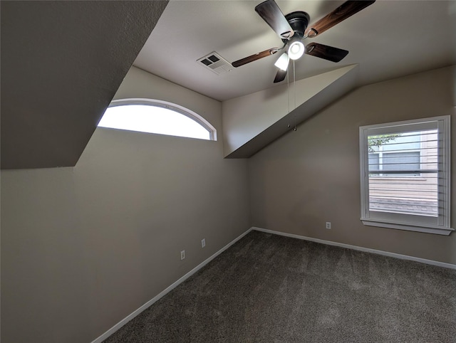 additional living space featuring dark carpet, a ceiling fan, lofted ceiling, and baseboards