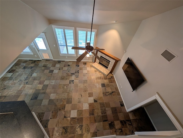 unfurnished living room featuring visible vents, ceiling fan, and baseboards