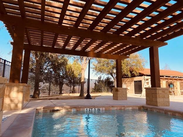 view of swimming pool featuring a pergola, a patio, a fenced in pool, and fence