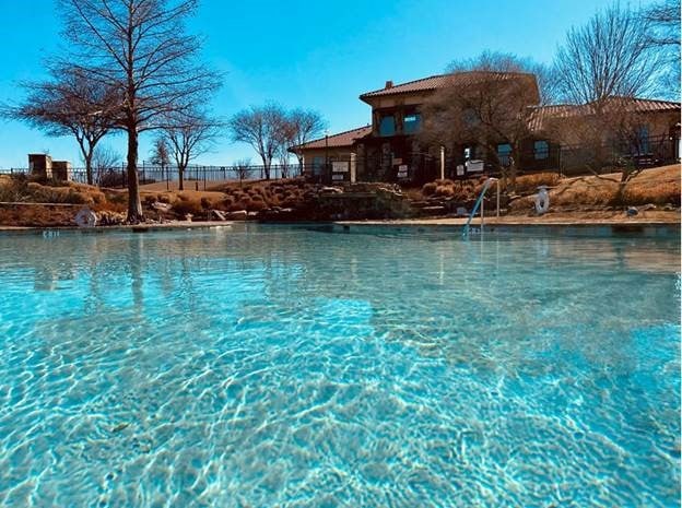 view of pool featuring a water view and fence