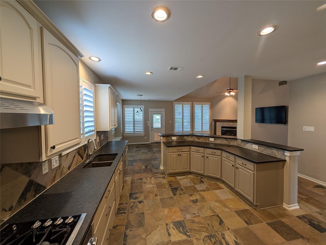kitchen featuring baseboards, visible vents, dark countertops, and a sink