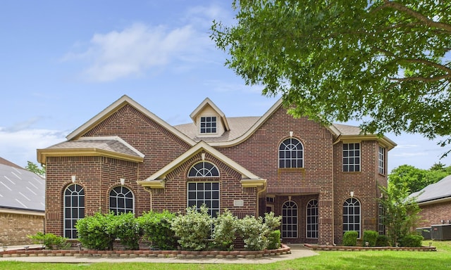 1264 Carriage Creek Dr, Desoto, TX 75115 - colonial home with brick siding, cooling unit, a shingled roof, and a front yard