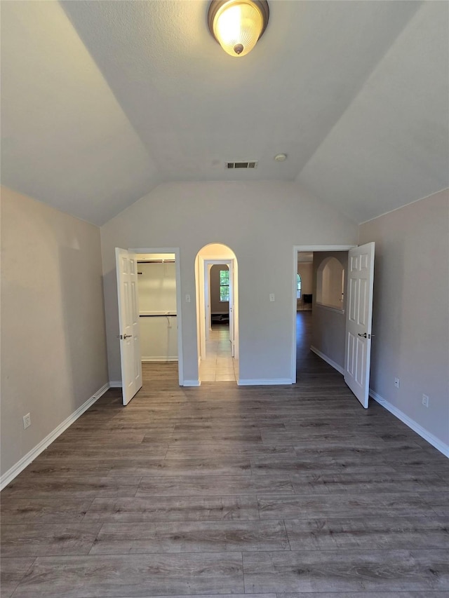 1264 Carriage Creek Dr, Desoto, TX 75115 - unfurnished bedroom with vaulted ceiling, arched walkways, wood finished floors, and baseboards