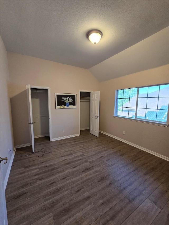 1264 Carriage Creek Dr, Desoto, TX 75115 - unfurnished bedroom featuring dark wood finished floors, vaulted ceiling, baseboards, and a textured ceiling