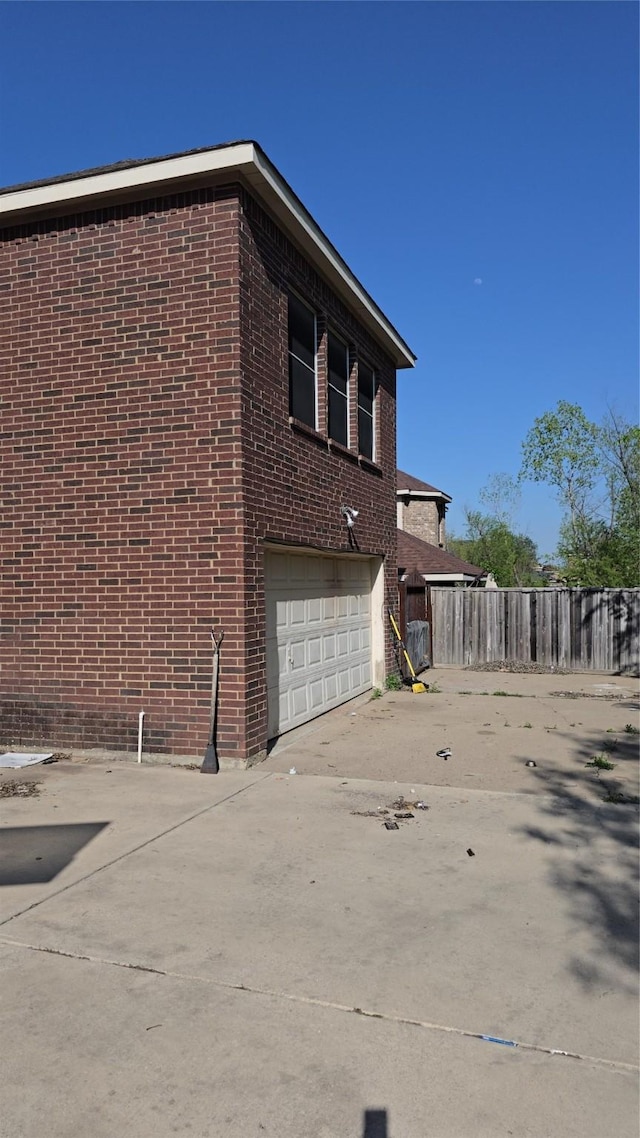 1264 Carriage Creek Dr, Desoto, TX 75115 - view of side of property featuring concrete driveway, a garage, brick siding, and fence