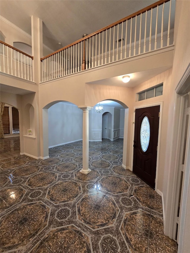 1264 Carriage Creek Dr, Desoto, TX 75115 - foyer featuring arched walkways, a high ceiling, ornate columns, inlaid floor details, and baseboards