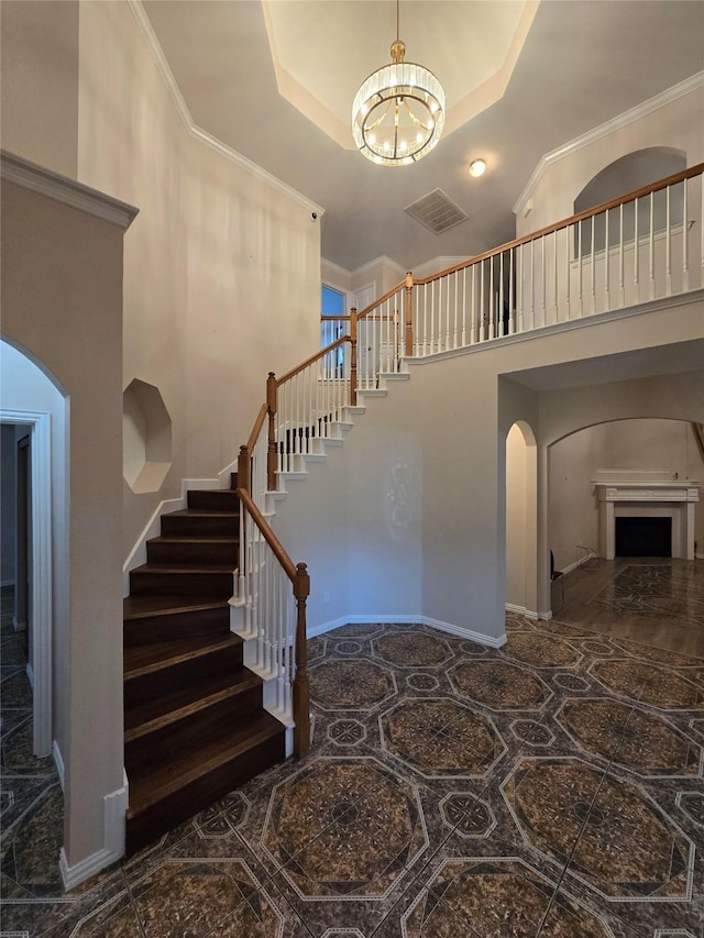 1264 Carriage Creek Dr, Desoto, TX 75115 - stairs with arched walkways, a chandelier, a towering ceiling, ornamental molding, and a fireplace