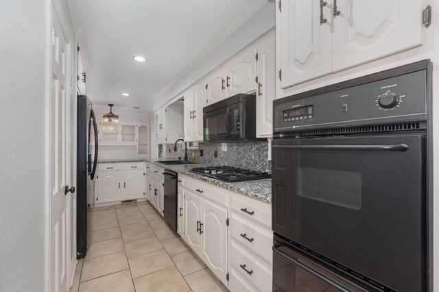 kitchen featuring light stone countertops, a sink, black appliances, light tile patterned flooring, and white cabinetry