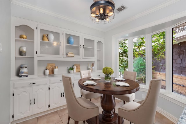 dining area with a chandelier, built in features, light tile patterned floors, visible vents, and ornamental molding