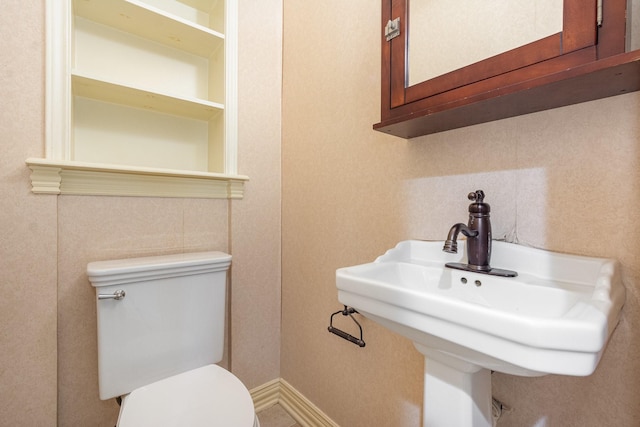 half bathroom featuring a sink and toilet