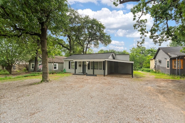 view of front facade featuring a carport and dirt driveway