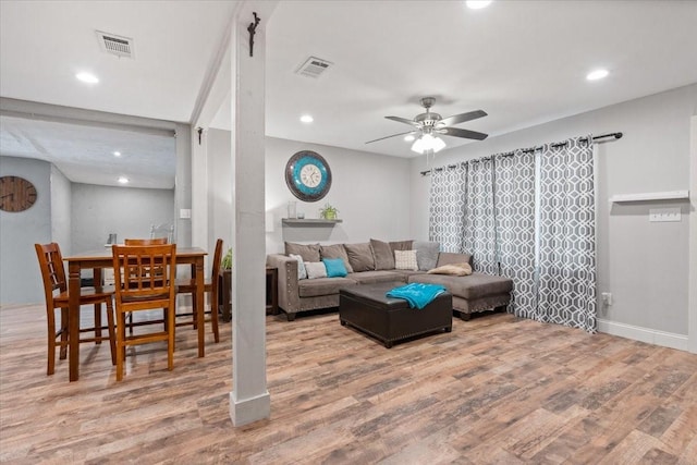 living area featuring visible vents, wood finished floors, and a ceiling fan