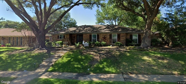 ranch-style home featuring a front yard and brick siding