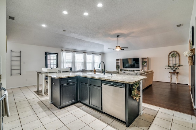 kitchen with a sink, visible vents, a textured ceiling, and dishwasher