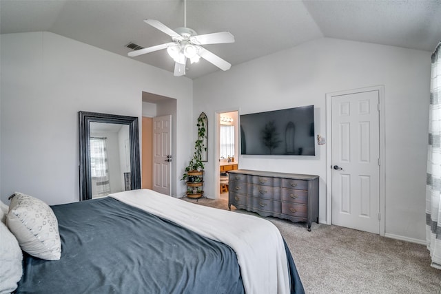 carpeted bedroom with a ceiling fan, visible vents, lofted ceiling, and ensuite bath