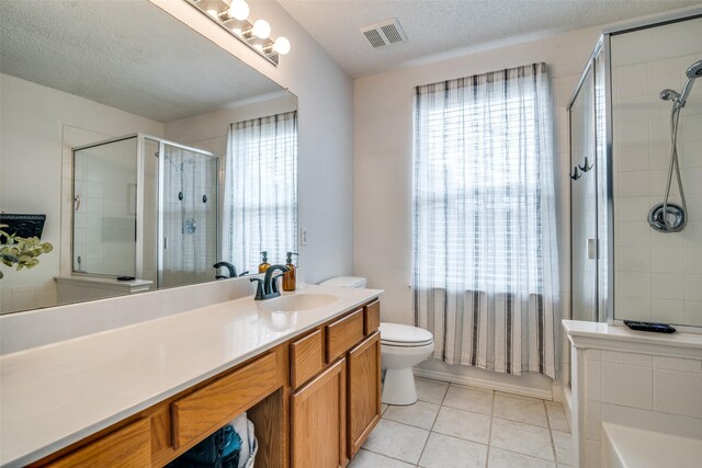 bathroom featuring a textured ceiling, visible vents, a shower stall, vanity, and tile patterned floors