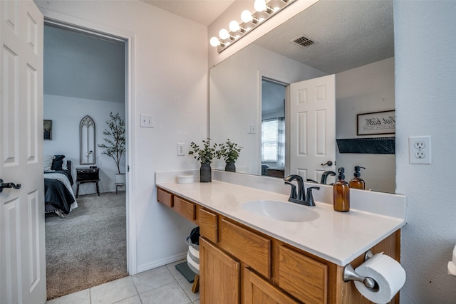 bathroom with vanity, ensuite bathroom, tile patterned flooring, and visible vents
