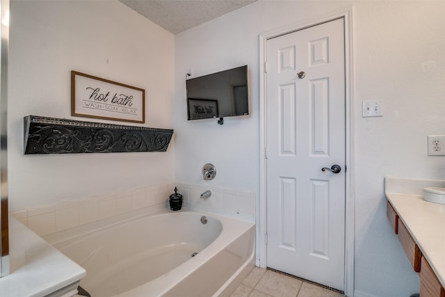 full bathroom featuring vanity, tile patterned flooring, a garden tub, and a textured ceiling
