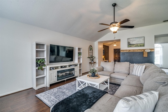 living area featuring a textured ceiling, dark wood finished floors, a glass covered fireplace, a ceiling fan, and lofted ceiling
