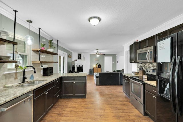 608 Timothy Dr, Fort Worth, TX 76028 - kitchen featuring a sink, open shelves, light wood-style flooring, backsplash, and appliances with stainless steel finishes