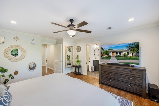 bedroom featuring crown molding, visible vents, and wood finished floors