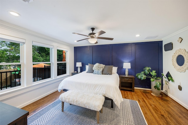 bedroom featuring visible vents, ornamental molding, baseboards, and wood finished floors