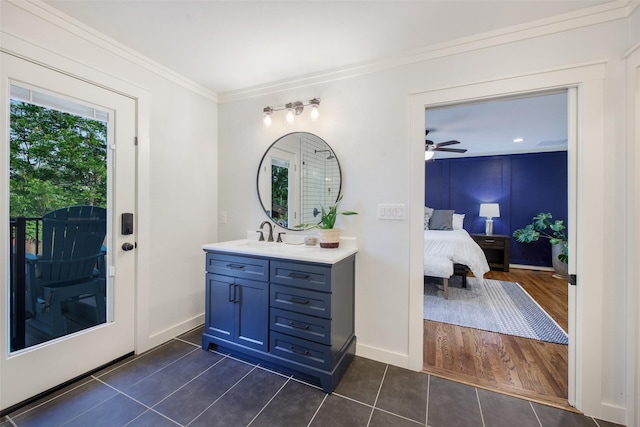 bathroom with vanity, ornamental molding, baseboards, tile patterned floors, and ensuite bath