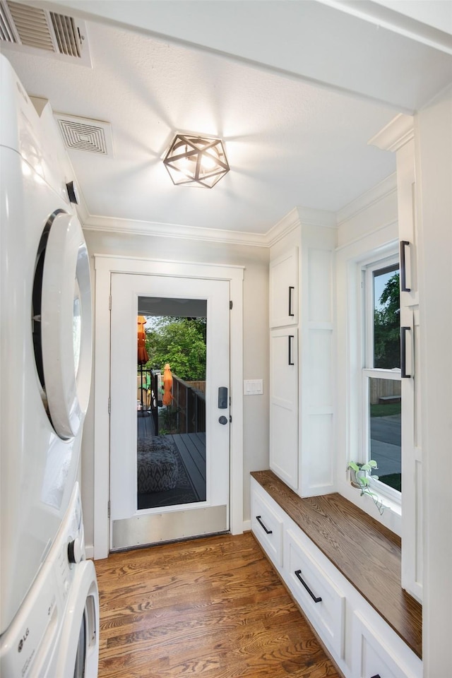 mudroom featuring visible vents, stacked washer and dryer, and a wealth of natural light