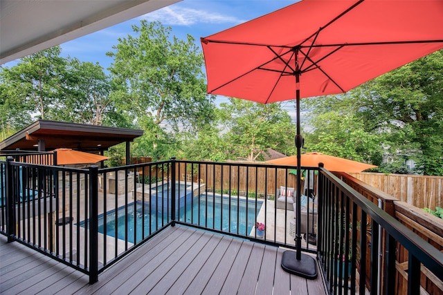 wooden deck featuring a patio, a fenced backyard, and a pool with connected hot tub