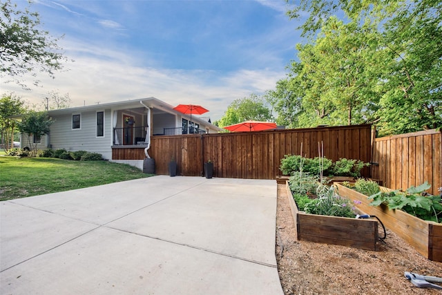 view of home's exterior featuring a yard, fence, and a vegetable garden