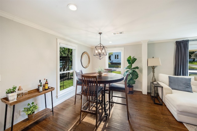 dining room featuring visible vents, crown molding, dark wood finished floors, baseboards, and a notable chandelier