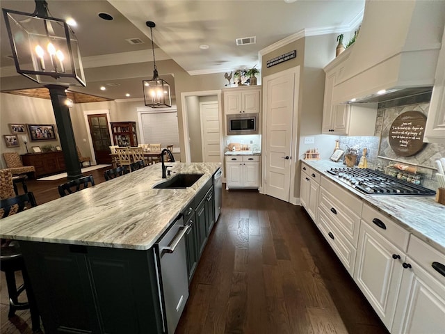 kitchen featuring crown molding, a breakfast bar area, a sink, and appliances with stainless steel finishes