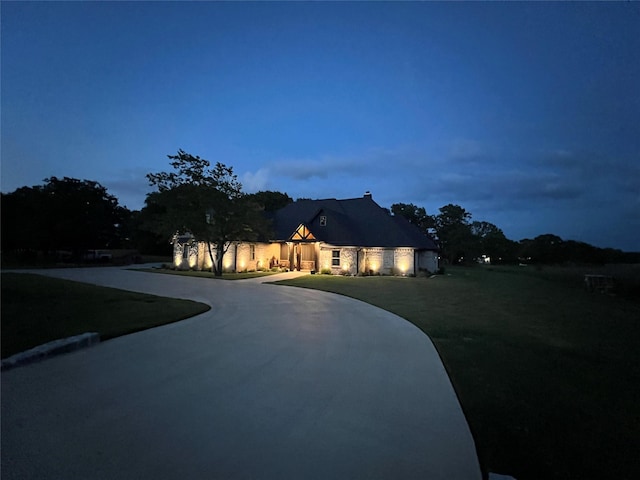 view of front of home with curved driveway and an attached garage