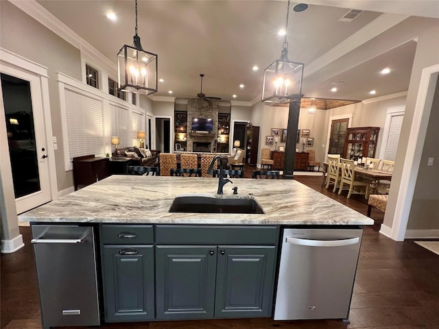 kitchen with a sink, ceiling fan, open floor plan, dishwasher, and a center island with sink