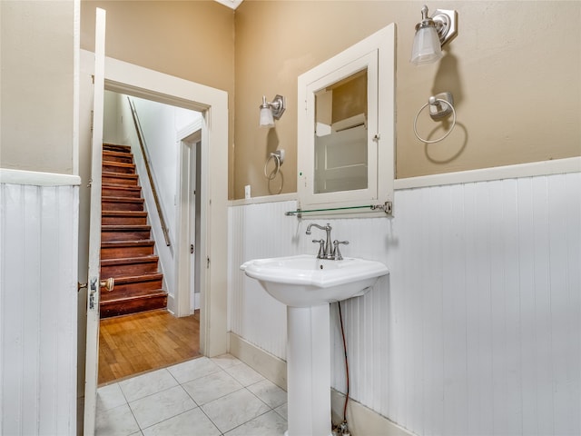 bathroom with tile patterned floors and a wainscoted wall