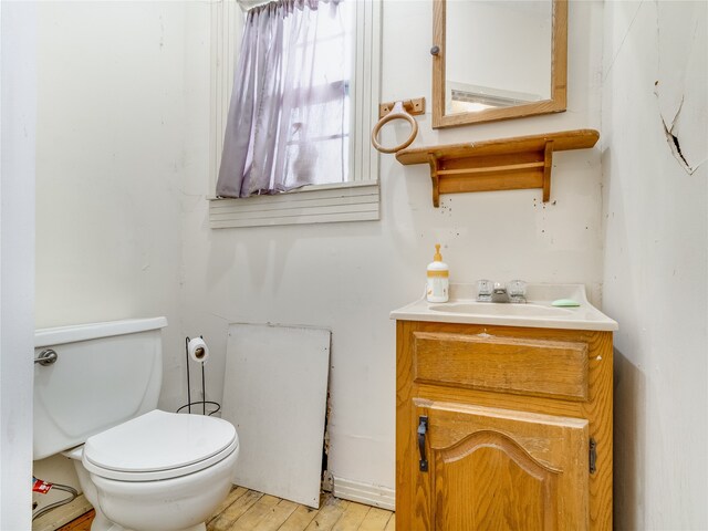 bathroom with vanity, toilet, and wood finished floors
