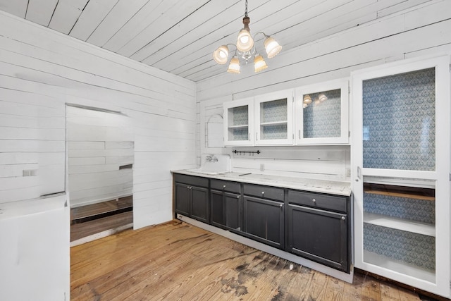 bathroom featuring wood-type flooring, a chandelier, wooden walls, and vanity