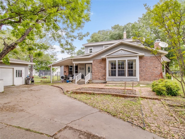 view of front of home featuring a chimney, concrete driveway, a porch, and brick siding